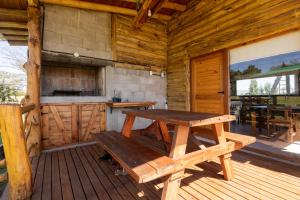 a wooden cabin with a picnic table and a kitchen at Mi lugar en el mundo in Villa Ciudad Parque