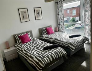 two beds sitting next to each other in a bedroom at 3BR-Sleeps 6 -Walk to Etihad & AO Arena in Manchester