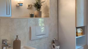 baño con lavabo y dispensador de jabón en la pared en Fewo Mohnrot - Fulgenhaus, en Klein Bollhagen