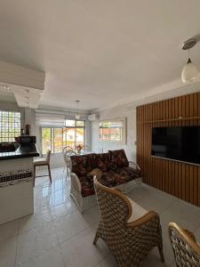 a living room with a couch and a tv at Apartamento enseada Guarujá in Guarujá