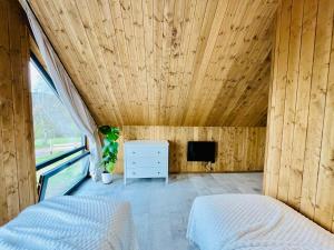 a bedroom with a wooden ceiling and a tv at Domki z widokiem na Sowę in Sierpnica