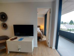 sala de estar con TV grande y dormitorio en 209 The Meadows, en George