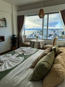 a large bed in a room with a large window at Studio vista al lago in San Carlos de Bariloche