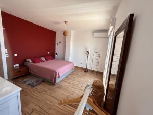 a bedroom with a bed with red pillows and a mirror at The Piano House in Rincón de la Victoria +51 photos