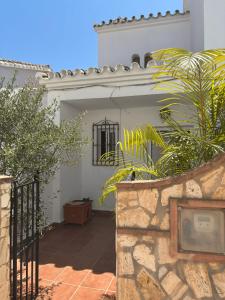 a white building with a gate and some plants at The Piano House in Rincón de la Victoria