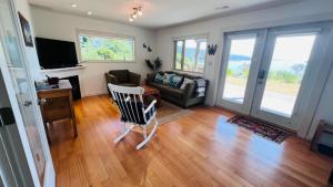 a living room with a couch and a tv at Oceanfront Garden Suite - Stunning Views & Wildlife in Halfmoon Bay +30 photos