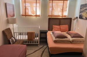 a bedroom with a bed and a crib and a crib at Downtown Historical House with Renovated apartments free P near in Ålesund