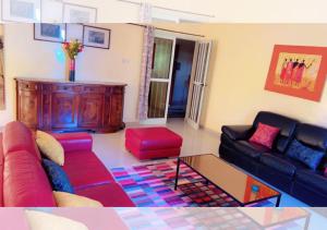 达喀尔Chez Ouly的客厅里有一张沙发和一张桌子。