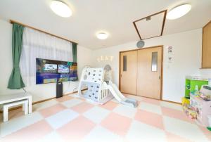 川越Kawagoe Inn Tokine 時の鐘まで徒歩3分 敷地内駐車場 お子様用プレイルーム的带有粉色和白色格子地板的儿童房