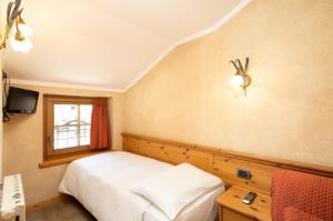 a bedroom with a bed and a window at Hotel La Pastorella in Livigno