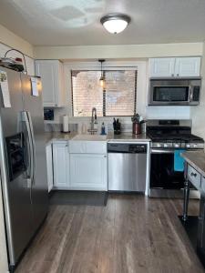 a kitchen with white cabinets and a stainless steel refrigerator at Townhouse In Bayview in Bayview