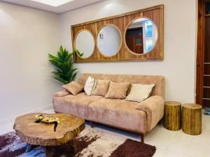 a living room with a couch and two mirrors at Luxurious Cozy Apartment in Kampala +3 photos