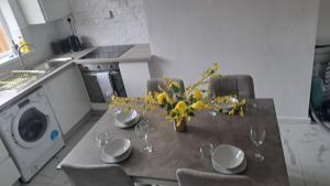 a table with glasses and a vase of flowers on it at Three-Bedroom House Perfect for Contractors and Small Groups, sleeps 5 people in Durham in Bishop Auckland