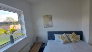 a bedroom with a bed with a window and a vase at Three-Bedroom House Perfect for Contractors and Small Groups, sleeps 5 people in Durham in Bishop Auckland