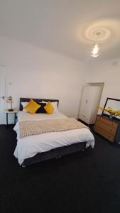 a bedroom with a large bed with yellow pillows at Three-Bedroom House Perfect for Contractors and Small Groups, sleeps 5 people in Durham in Bishop Auckland +16 photos