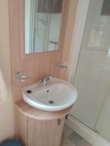 a bathroom with a sink and a mirror at Comfy caravan in Eyemouth in Eyemouth