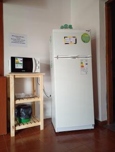 a white refrigerator next to a microwave next to a table at Departamento por dia in Posadas