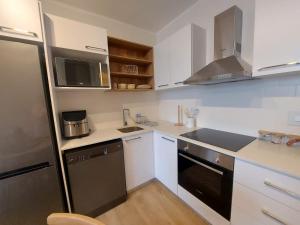 a small kitchen with white cabinets and a black dishwasher at 309 The Meadows in George