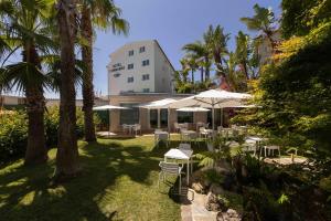 a patio with tables and umbrellas in front of a building at Hotel Combarro in Combarro