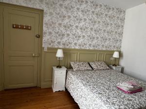 a bedroom with a bed and two lamps and a door at Au charme de Rilly in Rilly-la-Montagne