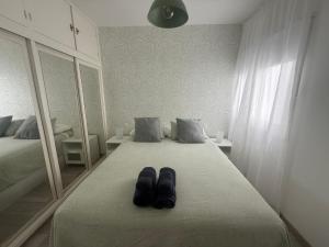a pair of shoes sitting on a bed in a bedroom at Paraíso playero en Las Palmas in Las Palmas de Gran Canaria