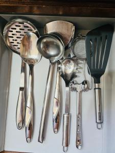 a bunch of kitchen utensils sitting in a drawer at Spacious Central Apartment in Tirana +15 photos