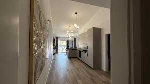 a hallway leading to a kitchen with white cabinets at Apartmani Srdarović in Drage