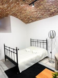 a bedroom with a black bed and a brick ceiling at Wagner's Refuge 1 in Riga