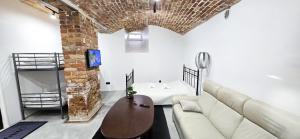a living room with a white couch and a brick wall at Wagner's Refuge 1 in Riga