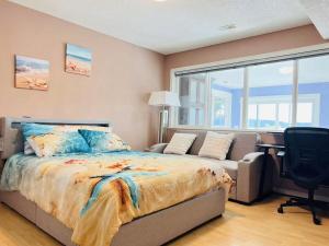 a bedroom with a bed and a couch and a desk at Stunning oceanfront home 4br3b sunrise beachcombing near Bamberton Park in Mill Bay