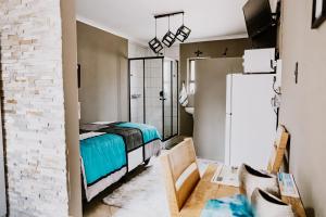 ein Schlafzimmer mit einem Bett und einer weißen Backsteinwand in der Unterkunft Cammys in Secunda