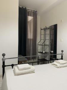 a bedroom with a bed with white sheets and a window at City Apartment in Ierapetra