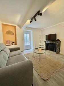a living room with a couch and a fireplace at Suites zen dans maison d'hôtes avec piscine intérieure et jardin in Ventenac-Cabardès