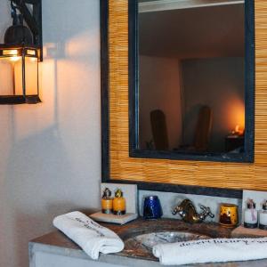 un baño con lavabo y espejo en TRIP Merzouga luxury camp, en Adrouine