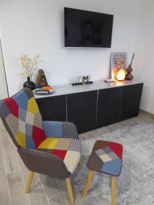 a living room with a colorful chair and a tv at Stella Apartment in Marina Palmense