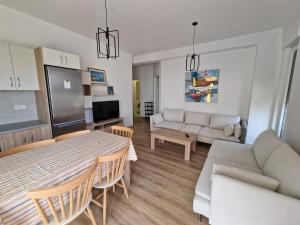 a kitchen and living room with a table and a couch at Apartament , White Rocks, Drimadhe in Himare +6 photos
