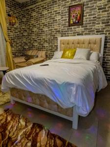 a bed in a bedroom with a brick wall at Country homes in Ruiru