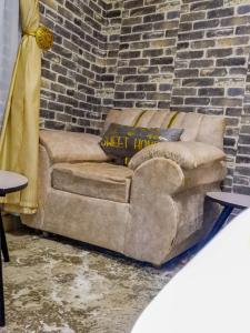 a couch sitting in front of a brick wall at Country homes in Ruiru