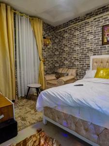 a bedroom with a bed and a brick wall at Country homes in Ruiru