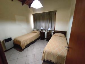 Una habitación de hotel con dos camas y una ventana. en Jardín del Piltri, en El Bolsón
