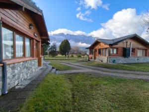una casa con un camino de piedra junto a un edificio en Jardín del Piltri, en El Bolsón