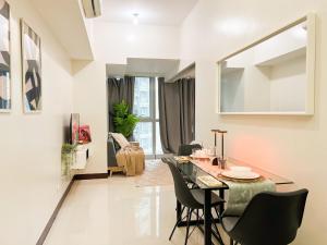 Un comedor y una sala de estar con mesa y sillas. en Stylish 1BR Prime BGC Uptown near Hyatt #upt119c, en Manila