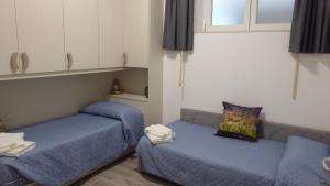 a room with two blue beds and a couch at Stella Apartment in Marina Palmense