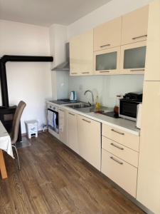 a kitchen with white cabinets and a sink at Adria in Brodarica
