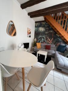 ブールジュにあるSéjour a Bourges avec Parkingの白いテーブルと椅子のあるリビングルーム