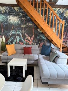 ブールジュにあるSéjour a Bourges avec Parkingのリビングルーム(カラフルな枕とソファ付)