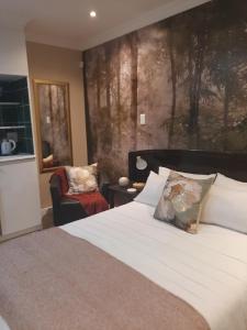 una camera da letto con un letto e un dipinto sul muro di Strandloper Room a Città del Capo