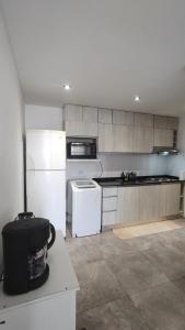a kitchen with a white refrigerator and a stove at El Hornero Barraca Puerto in Concepción del Uruguay