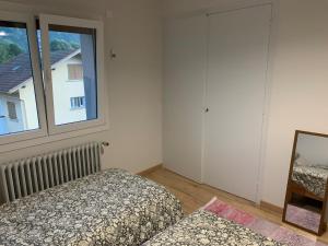 a bedroom with two beds and a window at Petit appartement dans une maison au calme in Bonneville