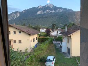 a car parked in a yard with houses and a mountain at Petit appartement dans une maison au calme in Bonneville